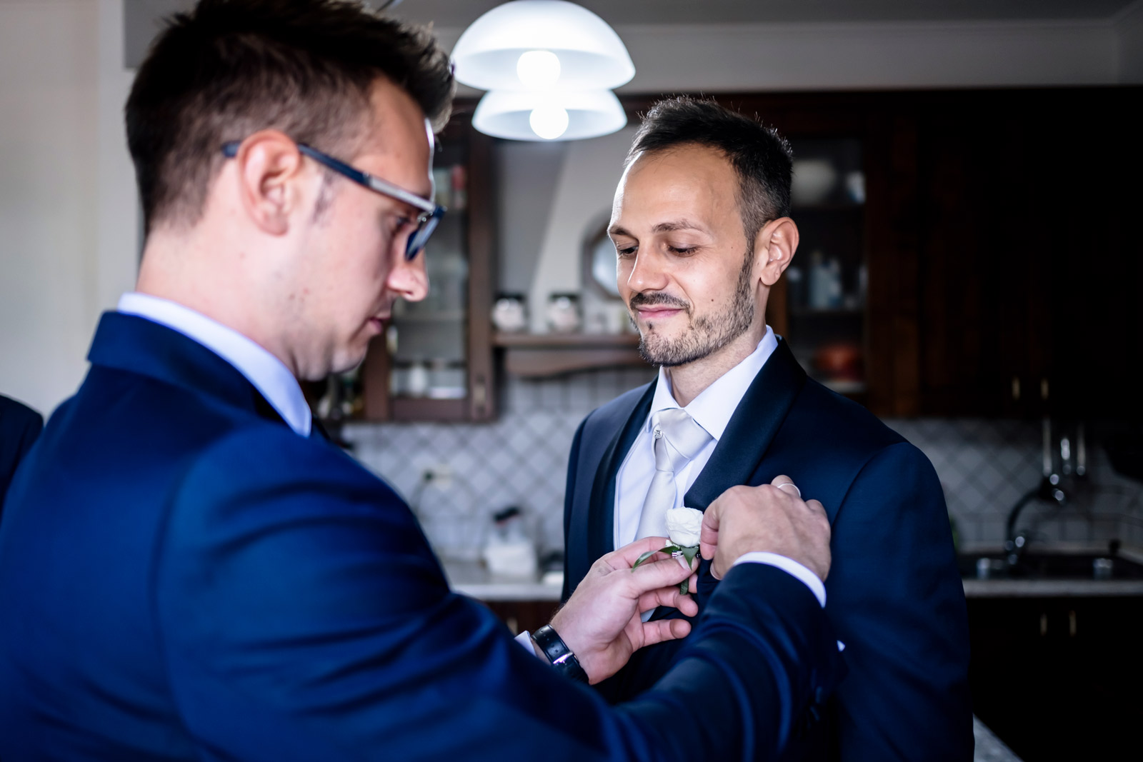 Il fratello di David che prepara lo sposo nella cucina dei loro genitori a Corchiano. Un luogo che loro conoscono bene, dove sono cresciuti e hanno condiviso tanti momenti.